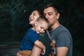 Happy young family father, mother and little son hugging and touching outdoors, playing together in summer park Royalty Free Stock Photo