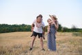 Happy young family. A father, a pregnant mother, and two little sons on their backs. Beveled wheat field on the background. Sunset Royalty Free Stock Photo