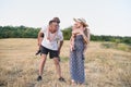 Happy young family. A father, a pregnant mother, and two little sons on their backs. Beveled wheat field on the background. Sunset Royalty Free Stock Photo