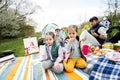 Happy young family, four kids having fun and enjoying outdoor on picnic blanket at garden spring park, relaxation Royalty Free Stock Photo