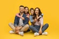 Happy young family of four sitting on floor and embracing Royalty Free Stock Photo