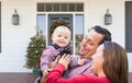 Happy Young Family On Front Porch of House With Christmas Decorations Royalty Free Stock Photo