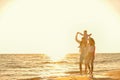 Happy young family have fun on beach run and jump at sunset Royalty Free Stock Photo