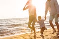 Happy young family have fun on beach run and jump at sunset Royalty Free Stock Photo
