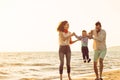 Happy young family have fun on beach run and jump at sunset Royalty Free Stock Photo