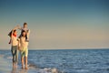 Happy young family have fun on beach run and jump at sunset Royalty Free Stock Photo