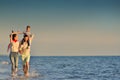 Happy young family have fun on beach run and jump at sunset Royalty Free Stock Photo