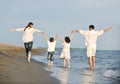 Happy young family have fun on beach at sunset Royalty Free Stock Photo