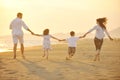 Happy young family have fun on beach at sunset Royalty Free Stock Photo