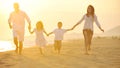 Happy young family have fun on beach at sunset Royalty Free Stock Photo