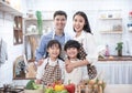 Happy young family have leisure time in kitchen,handsome caucasian father with asian mother and their daughter and son with happy Royalty Free Stock Photo