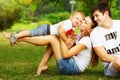 Happy young family is having fun in the green summer park outdoors on a sunny day. Mother, father and their little baby-boy are w Royalty Free Stock Photo