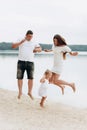 Happy young family having fun near the lake, mom dad and daughter playing outdoors. summer holiday, Mother`s, father`s, baby`s Royalty Free Stock Photo