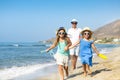 Happy young family having fun running on beach at sunset. Family Royalty Free Stock Photo