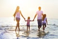 Happy young family having fun running on beach at sunset Royalty Free Stock Photo