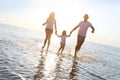 Happy young family having fun running on beach at sunset Royalty Free Stock Photo