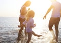 Happy young family having fun running on beach at sunset Royalty Free Stock Photo