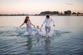 Happy young family having fun running on water at the beach Royalty Free Stock Photo