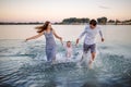 Happy young family having fun running on water at the beach Royalty Free Stock Photo