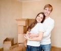 Happy young family hugging on a background of cardboard boxes Royalty Free Stock Photo