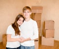 Happy young family hugging on a background of cardboard boxes Royalty Free Stock Photo