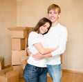 Happy young family hugging on a background of cardboard boxes Royalty Free Stock Photo