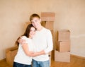 Happy young family hugging on a background of cardboard boxes Royalty Free Stock Photo