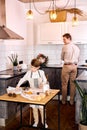 Happy young family, kid making baking cookies in modern kitchen while dad wash the dishes Royalty Free Stock Photo