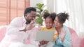 Happy young family with kids laughing watching video call on laptop. Family using digital tablet video call application with their Royalty Free Stock Photo