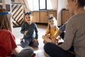 Happy young family with kids playing a card game at home sitting on the floor Royalty Free Stock Photo