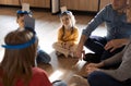 Happy young family with kids playing a card game at home sitting on the floor Royalty Free Stock Photo