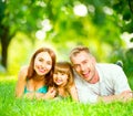 Happy young family lying on green grass Royalty Free Stock Photo