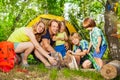 Happy young family making camp fire in the woods