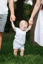 Happy young family, mom, dad and baby son spending time together outdoors in summer green garden. parents holding their Royalty Free Stock Photo