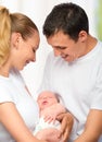 Happy young family of mother, father and newborn baby in their a Royalty Free Stock Photo
