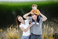 Happy young family near lake, pond. Family enjoying life together at meadow. People having fun in nature. Family bonds outside. Royalty Free Stock Photo