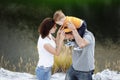 Happy young family near lake, pond. Family enjoying life together at meadow. People having fun in nature. Family bonds outside. Royalty Free Stock Photo