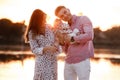 Happy young family near lake, pond. Family enjoying life together at sunset. People having fun in nature. Family look Royalty Free Stock Photo