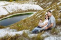 Happy young family near lake, pond. Family enjoying life together at meadow. People having fun in nature. Family bonds outside. Royalty Free Stock Photo