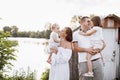 Happy young family near lake, pond on summer on countryside. Mother, father and two child daughter smiling and having Royalty Free Stock Photo