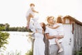 Happy young family near lake, pond on summer on countryside. Mother, father and two child daughter smiling and having Royalty Free Stock Photo