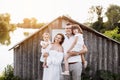 Happy young family near lake, pond on summer on countryside. Mother, father and two child daughter smiling while Royalty Free Stock Photo