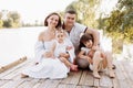 Happy young family near lake, pond on summer. Mother, father and two child daughter smiling while spending free time Royalty Free Stock Photo