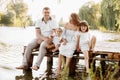 Happy young family near lake, pond on summer. Mother, father and two child daughter smiling while spending free time Royalty Free Stock Photo