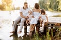 Happy young family near lake, pond on summer. Mother, father and two child daughter smiling while spending free time Royalty Free Stock Photo