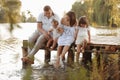 Happy young family near lake, pond on summer. Mother, father and two child daughter smiling while spending free time Royalty Free Stock Photo