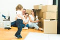 Happy young family, parents daughter and son, unpacking boxes and moving into a new home. funny kids run in with boxes Royalty Free Stock Photo