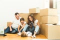 Happy young family, parents daughter and son, unpacking boxes and moving into a new home. funny kids run in with boxes Royalty Free Stock Photo