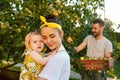 The happy young family during picking apples in a garden outdoors Royalty Free Stock Photo