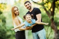 Happy young family play in summer park. Mother, father and daughter fly in the summer park. Royalty Free Stock Photo